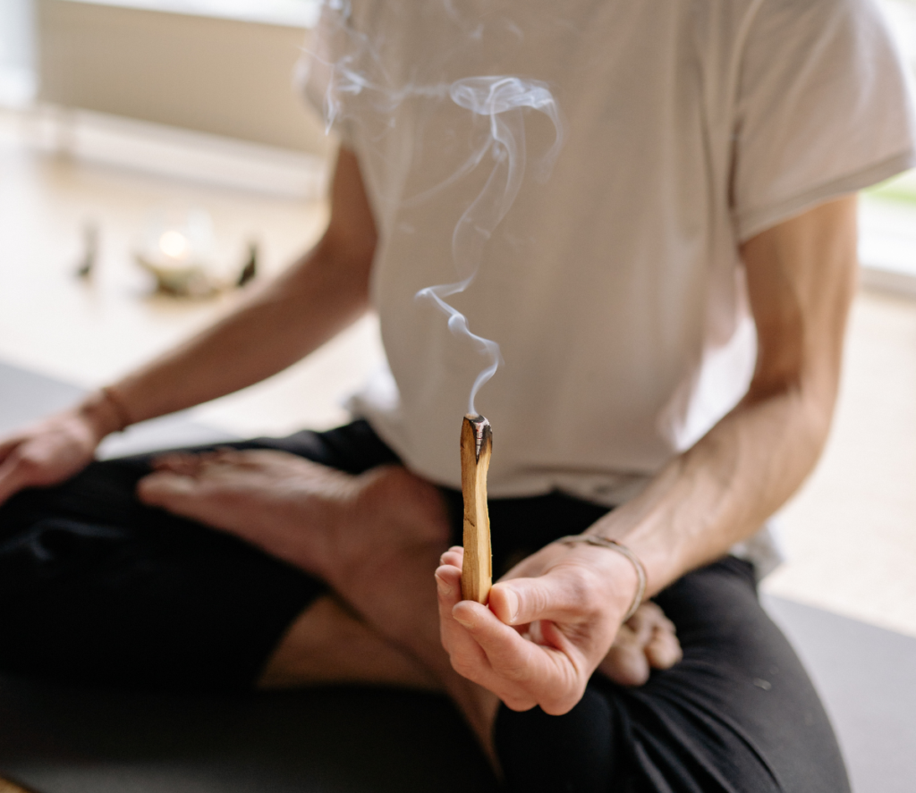 sitting in lotus holding burning incense 
